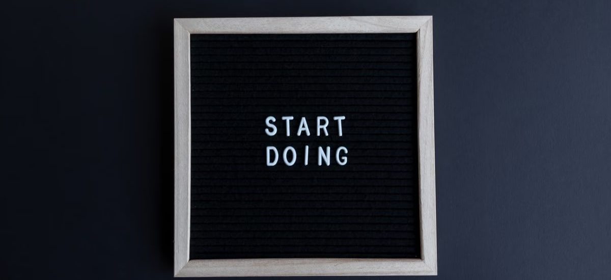 Black letter board with the motivational phrase 'Start Doing' in white text on a gray background.