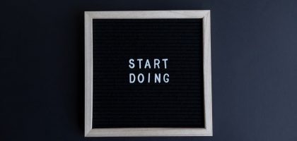 Black letter board with the motivational phrase 'Start Doing' in white text on a gray background.