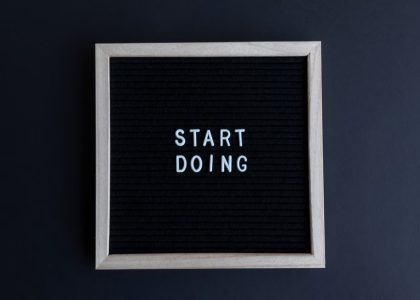 Black letter board with the motivational phrase 'Start Doing' in white text on a gray background.